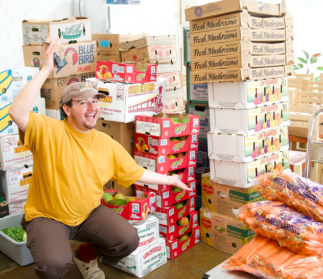 volunteer in front of produce in crates